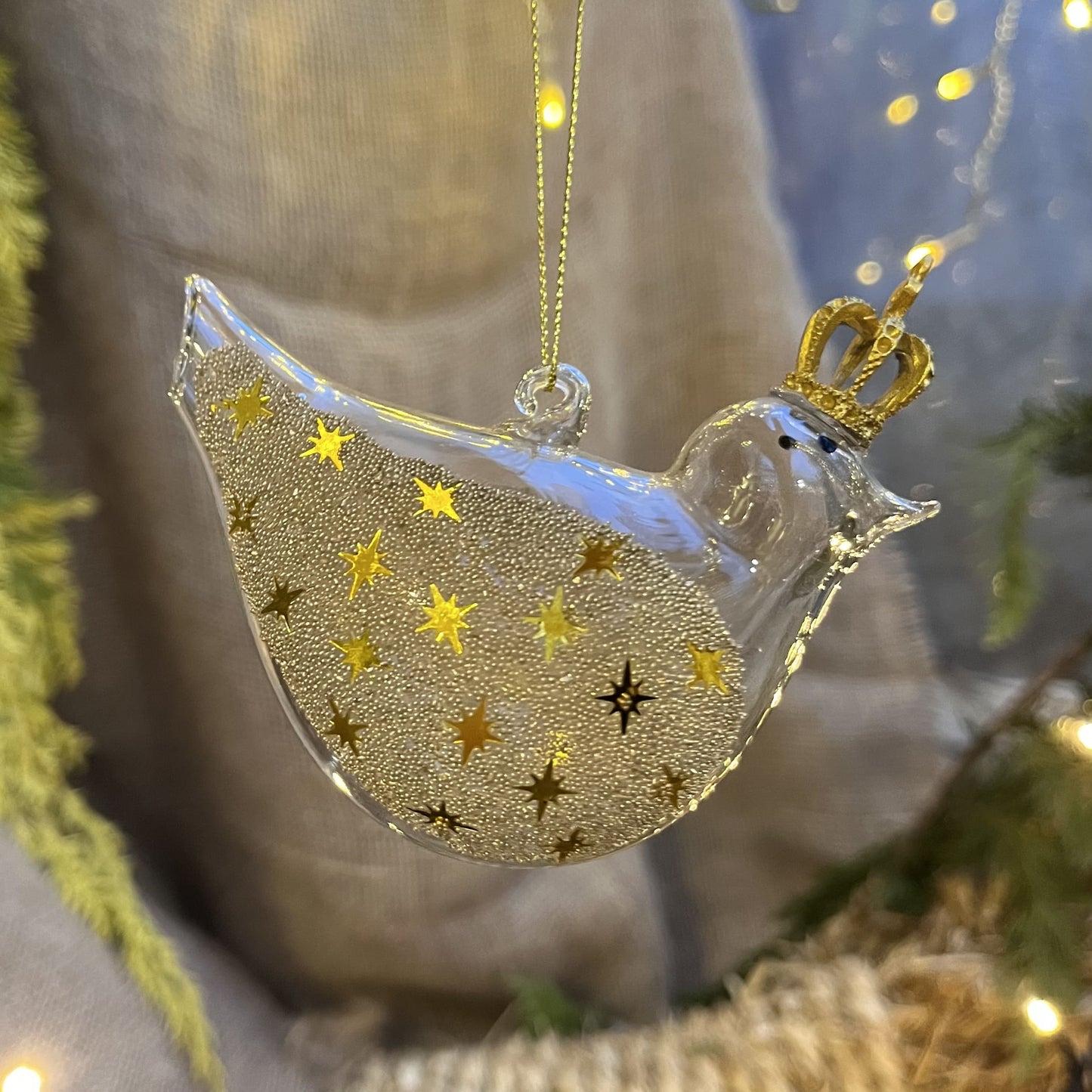 Lass dich von diesem einzigartigen und verspielten Glasvogel verzaubern! Mit seiner goldenen Krone und den mit Sternchen und Perlen besetzen Glitzerflügeln versprüht er einen ganz besonderen Charme.
Maße: ca. 10,0cm
Materialien: Glas, Perlen, Kunststoff
Farben: Gold