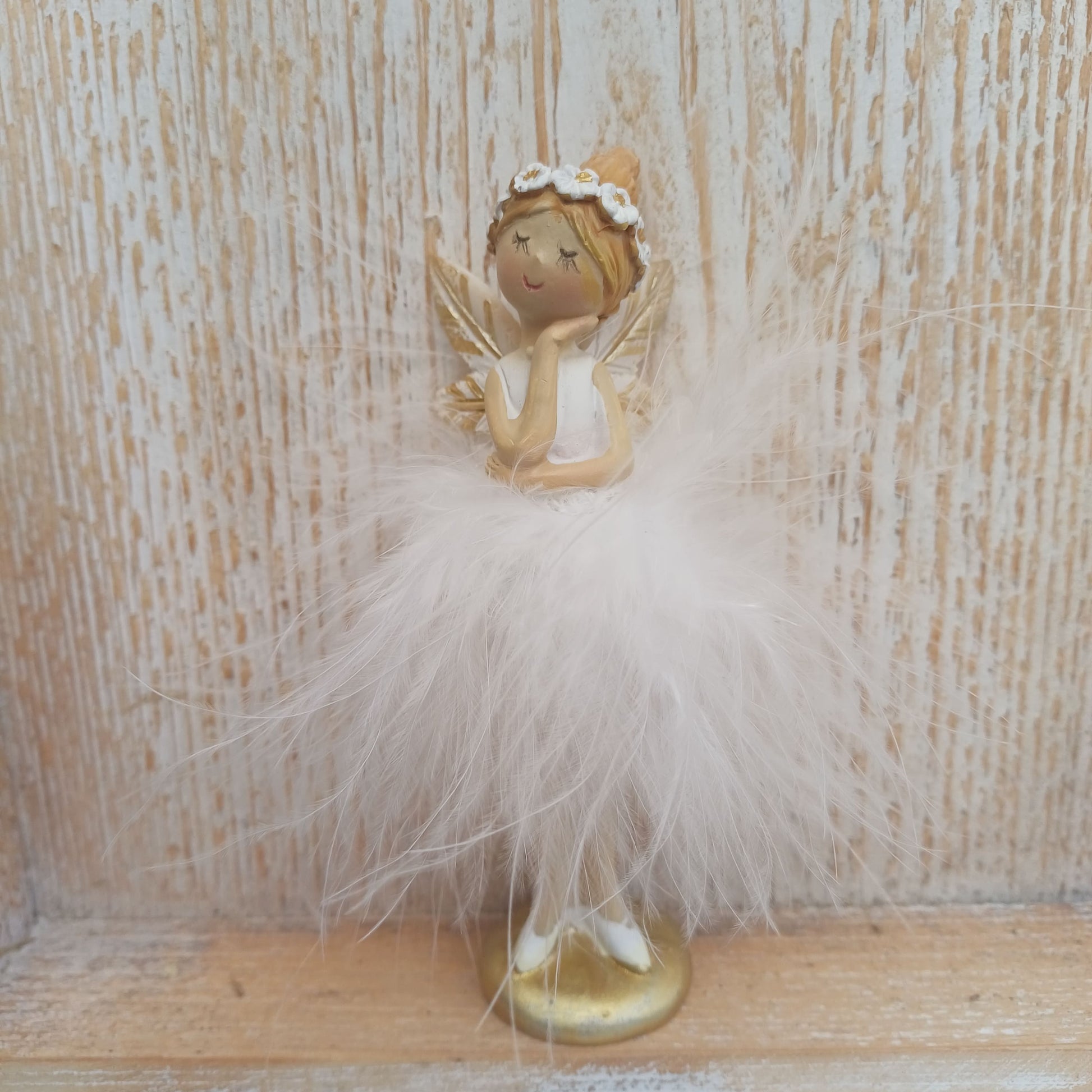 Elfe mit Federn - stehend - in weiß / gold und 2 Varianten erhältlich. Entweder mit der Hand unter dem Kinn, oder mit gefalteten Händen vor der Brust. 
Maße: Höhe ca. 12 cm 
Material: Polyresin, Federn 
Farben: rosa, apricot 
Lieferumfang: 1 Elfe in der ausgesuchten Variante