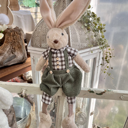 Kantenhocker Hase mit grüner Hose und kariertem Hemd. Seine Arme können in alle Richtungen gebogen werden. Dadurch kann er ständig ein neues Aussehen annehmen. Frech sieht er aus, wenn auf einem Hocker sitzt, oder seine Beine einfach irgendwo hinunter baumeln lässt. Höhe: ca. 55 cm (ca 35 cm sitzend + ca 20 cm Füße) 
Gewicht: ca. 480 g - Material: Fell, Stoff, Strick, Kunststoff - Farbe: hellbraun, grün, schwarz, weiß, rosa - 
Lieferumfang: 1 Hase (ohne Hocker)