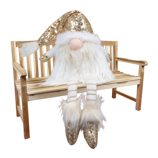 Wichtel als Kantenhocker mit einer Stoffmütze. Die Mütze, sowie die Schuhe sind mit goldenen Pailletten besetzt. Durch den weißen Kontrast erscheint er in einer sehr edle Optik. Durch seinen leicht angegrauten Bart wirkt er sehr erhaben. 
Höhe: ca. 40 cm - Material: Stoff, Filz, Pailletten, Fell - Farben: gold, weiß