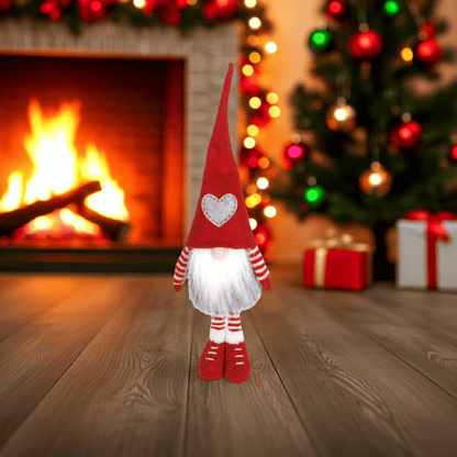 Wichtel - Santa stehend mit grauem Herz auf der Mütze, sowie gestreifte Strickarme und Beine. Der Wichtel besteht aus einem strapazierfähigen Filz und einer Holznase .  
Höhe: ca. 48 cm - Gewicht:&nbsp; ca. 200 g - Material: Filz, Holz - Farben: rot, weiß, grau