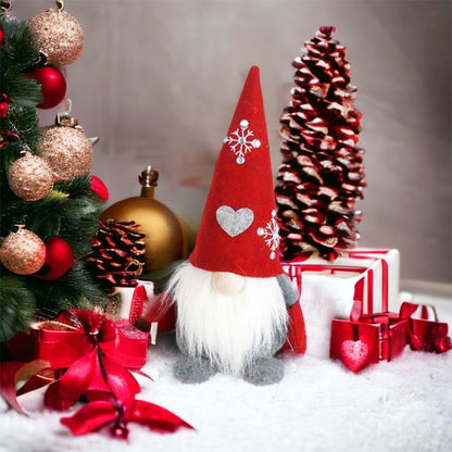 Wichtel - Santa sitzend mit Herz auf der Mütze, sowie gestickter Schneeflocke mit Strasssteinen. Der Wichtel besteht aus einem strapazierfähigen Filz mit einer Holznase . Höhe: ca. 23 cm - 
Gewicht: ca. 200 g - Applikationen: Gestickte Schneeflocke mit Strasssteinen - Material: Filz, Holz, Strasssteine - Farben: rot, weiß, grau