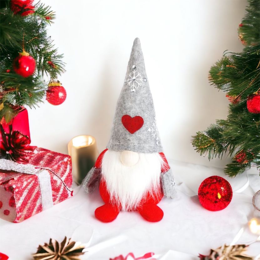 Wichtel - Santa sitzend mit Herz auf der Mütze, sowie gestickter Schneeflocke mit Strasssteinen. Der Wichtel besteht aus einem strapazierfähigen Filz und einer Holznase . Höhe: ca. 23 cm - 
Gewicht: ca. 200 g - Applikationen: Gestickte Schneeflocke mit Strasssteinen - Material: Filz, Holz, Strasssteine - Farben: grau, rot, weiß