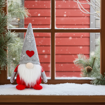 Wichtel - Santa sitzend mit Herz auf der Mütze, sowie gestickter Schneeflocke mit Strasssteinen. Der Wichtel besteht aus einem strapazierfähigen Filz und einer Holznase . Höhe: ca. 23 cm - 
Gewicht: ca. 200 g - Applikationen: Gestickte Schneeflocke mit Strasssteinen - Material: Filz, Holz, Strasssteine - Farben: grau, rot, weiß