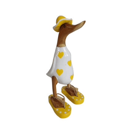 Bambusente - mit gelben Herzen, orangen Flip Flops und Sonnenhut und einer Höhe von 25 cm.       Wunderschöne Deko aus Bambuswurzel. Jedes Teil handgefertigt und ein Unikat. Ein Hingucker für Drinnen und Draußen.
Zudem stehen die Enten aus Bambus für Familie, Treue & Liebe und Holz für Wachstum. So macht es sie dadurch auch zu einem bedeutungsvollen Geschenk für einen lieben Menschen.