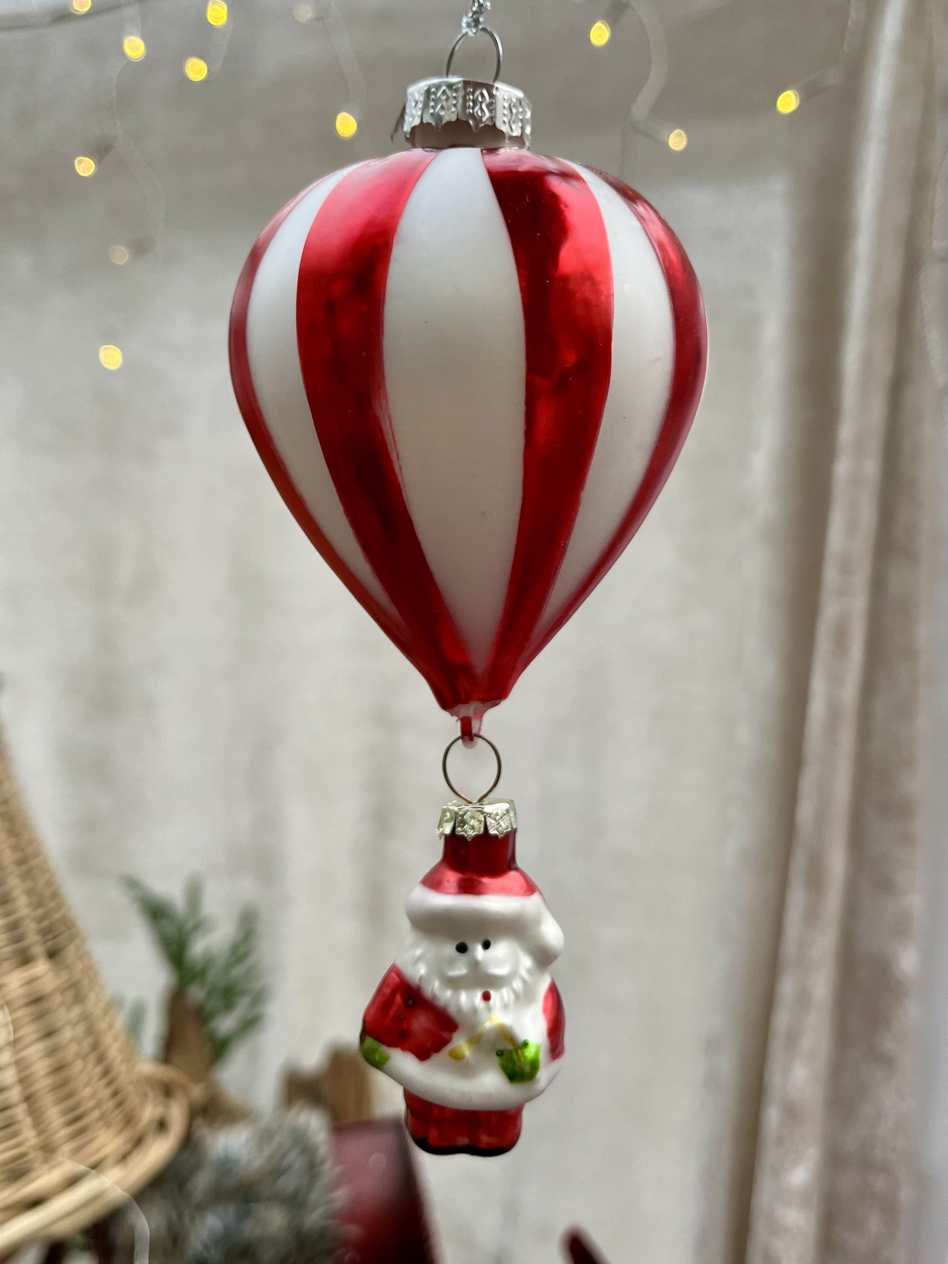Diese schillernde Christbaumkugel "Santa als Ballonfahrer" wird zum Hingucker auf jedem festlichen Baum! Mit ihrem verspielten Motiv eines fröhlichen Nikolaus bringt sie eine charmante Atmosphäre in dein Zuhause. Maße: H15,0cm D 7 cm + Hänger Farben: bunt 
Material: Glas, Metall