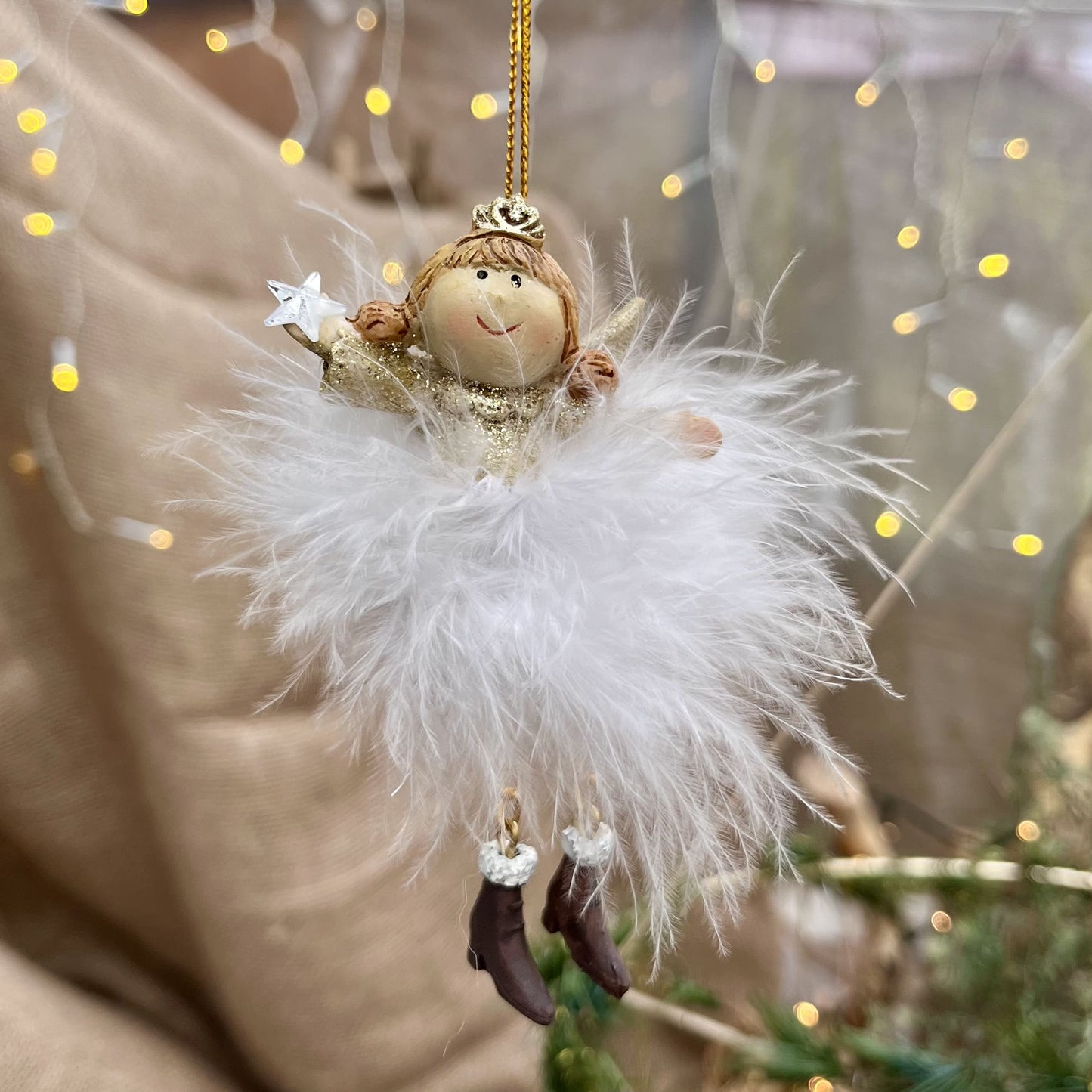 Dieser zarte Federengel mit Krönchen verleiht eurem Weihnachtsbaum eine besondere Note. Das federleichte Kleid wiegt sanft auf und ab und sorgt für eine beruhigende, festliche Atmosphäre. Mit einer Höhe von ca. 11,5 cm ist er in zwei eleganten Varianten erhältlich und bringt himmlischen Glanz in eure Weihnachtsdekoration.