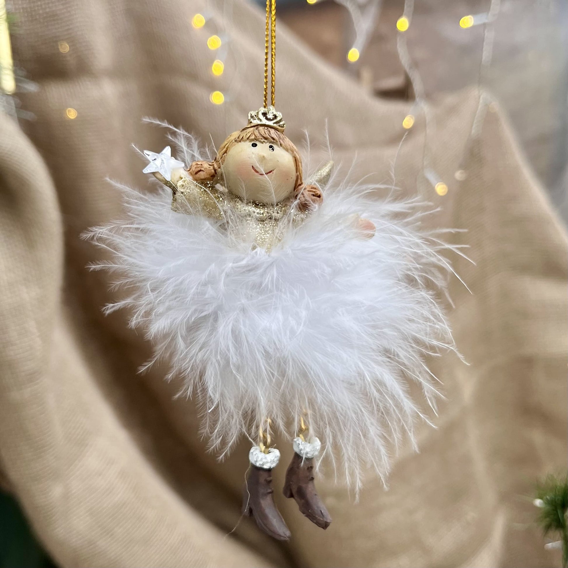 Dieser zarte Federengel mit Krönchen verleiht eurem Weihnachtsbaum eine besondere Note. Das federleichte Kleid wiegt sanft auf und ab und sorgt für eine beruhigende, festliche Atmosphäre. Mit einer Höhe von ca. 11,5 cm ist er in zwei eleganten Varianten erhältlich und bringt himmlischen Glanz in eure Weihnachtsdekoration.