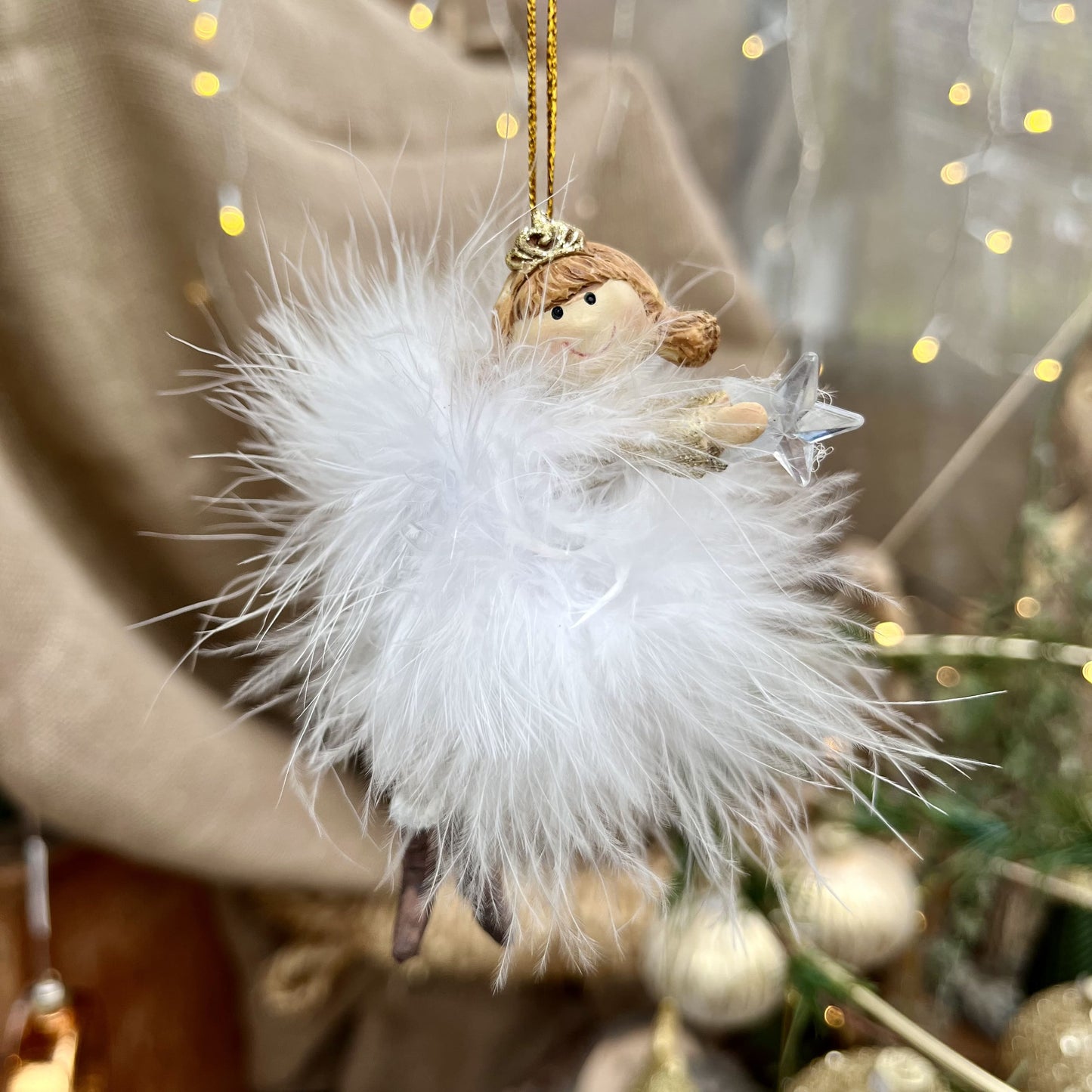 Dieser zarte Federengel mit Krönchen verleiht eurem Weihnachtsbaum eine besondere Note. Das federleichte Kleid wiegt sanft auf und ab und sorgt für eine beruhigende, festliche Atmosphäre. Mit einer Höhe von ca. 11,5 cm ist er in zwei eleganten Varianten erhältlich und bringt himmlischen Glanz in eure Weihnachtsdekoration.