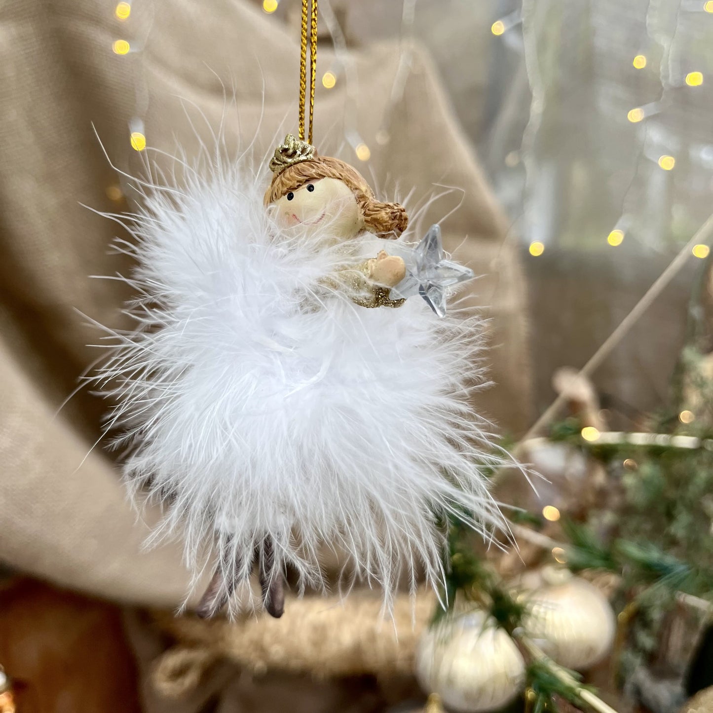 Dieser zarte Federengel mit Krönchen verleiht eurem Weihnachtsbaum eine besondere Note. Das federleichte Kleid wiegt sanft auf und ab und sorgt für eine beruhigende, festliche Atmosphäre. Mit einer Höhe von ca. 11,5 cm ist er in zwei eleganten Varianten erhältlich und bringt himmlischen Glanz in eure Weihnachtsdekoration.