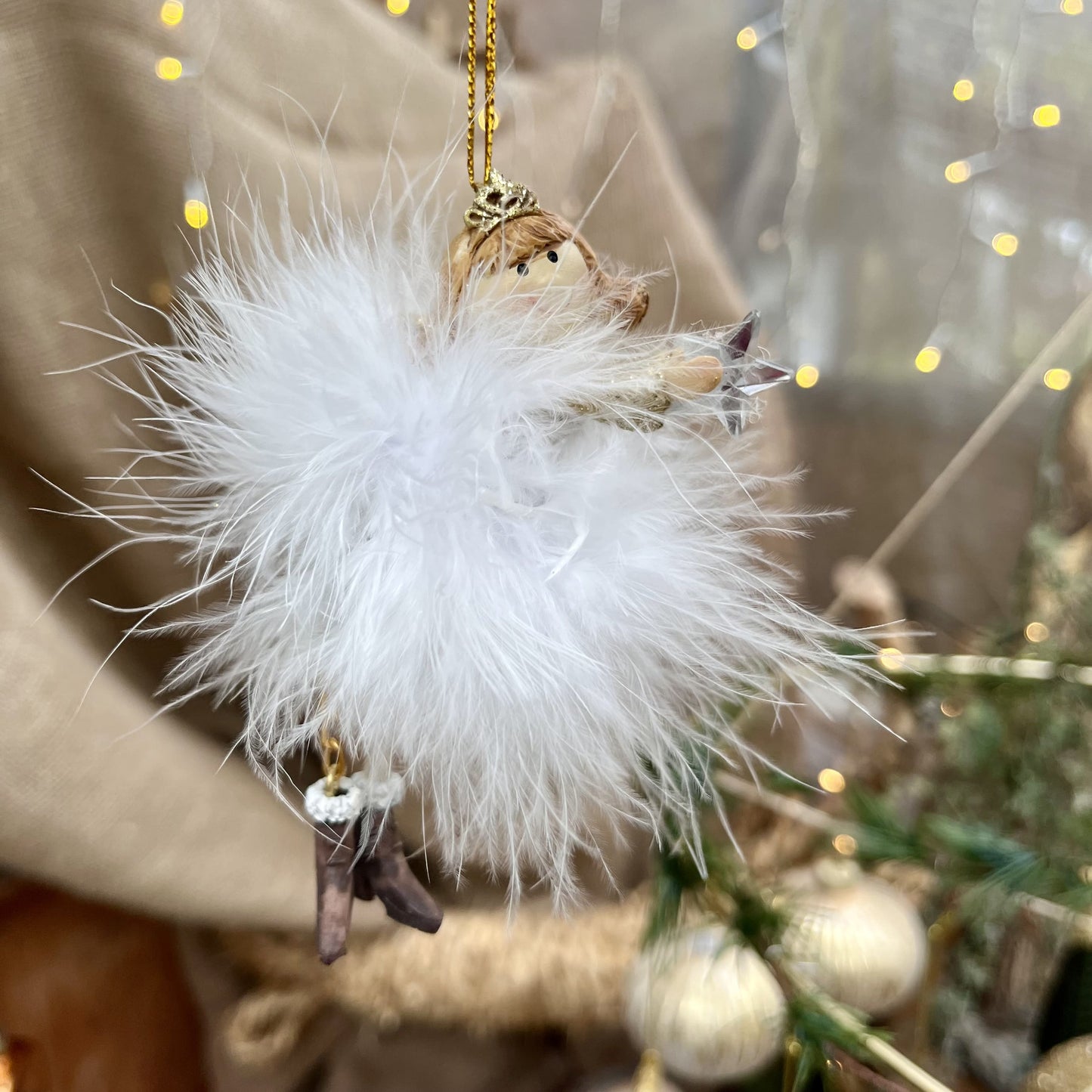 Dieser zarte Federengel mit Krönchen verleiht eurem Weihnachtsbaum eine besondere Note. Das federleichte Kleid wiegt sanft auf und ab und sorgt für eine beruhigende, festliche Atmosphäre. Mit einer Höhe von ca. 11,5 cm ist er in zwei eleganten Varianten erhältlich und bringt himmlischen Glanz in eure Weihnachtsdekoration.