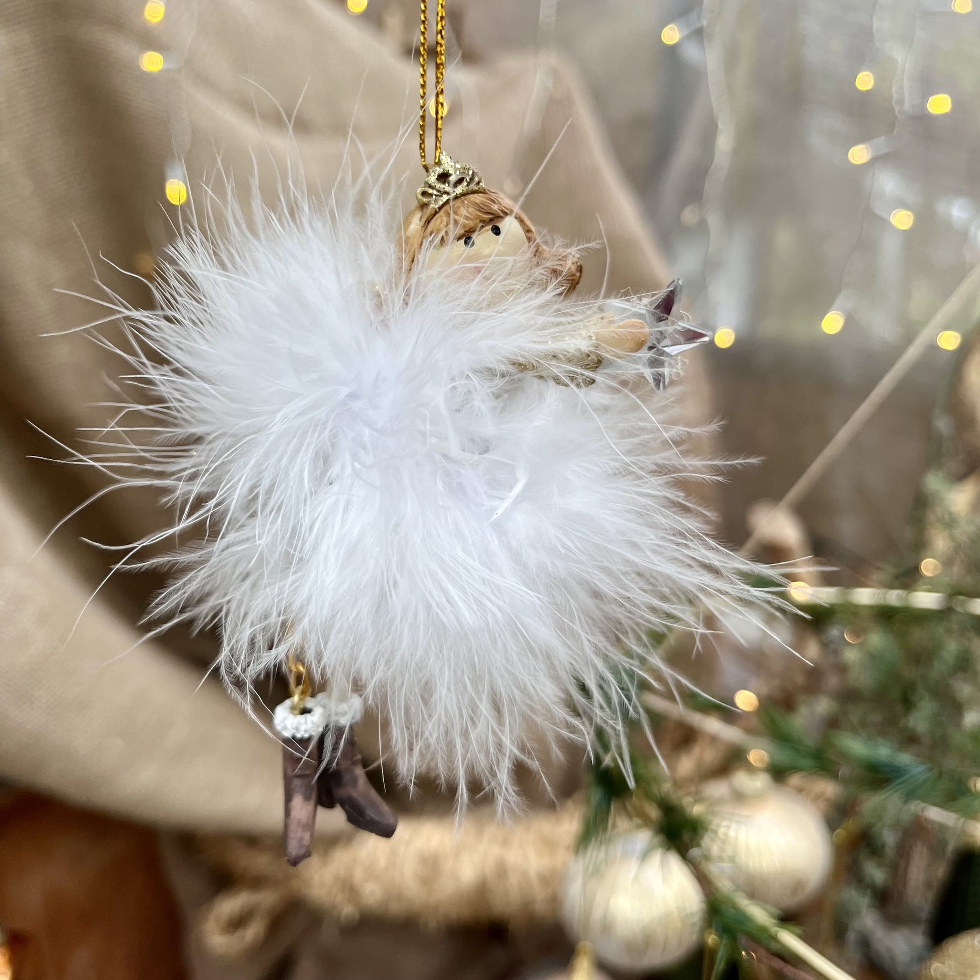 Dieser zarte Federengel mit Krönchen verleiht eurem Weihnachtsbaum eine besondere Note. Das federleichte Kleid wiegt sanft auf und ab und sorgt für eine beruhigende, festliche Atmosphäre. Mit einer Höhe von ca. 11,5 cm ist er in zwei eleganten Varianten erhältlich und bringt himmlischen Glanz in eure Weihnachtsdekoration.