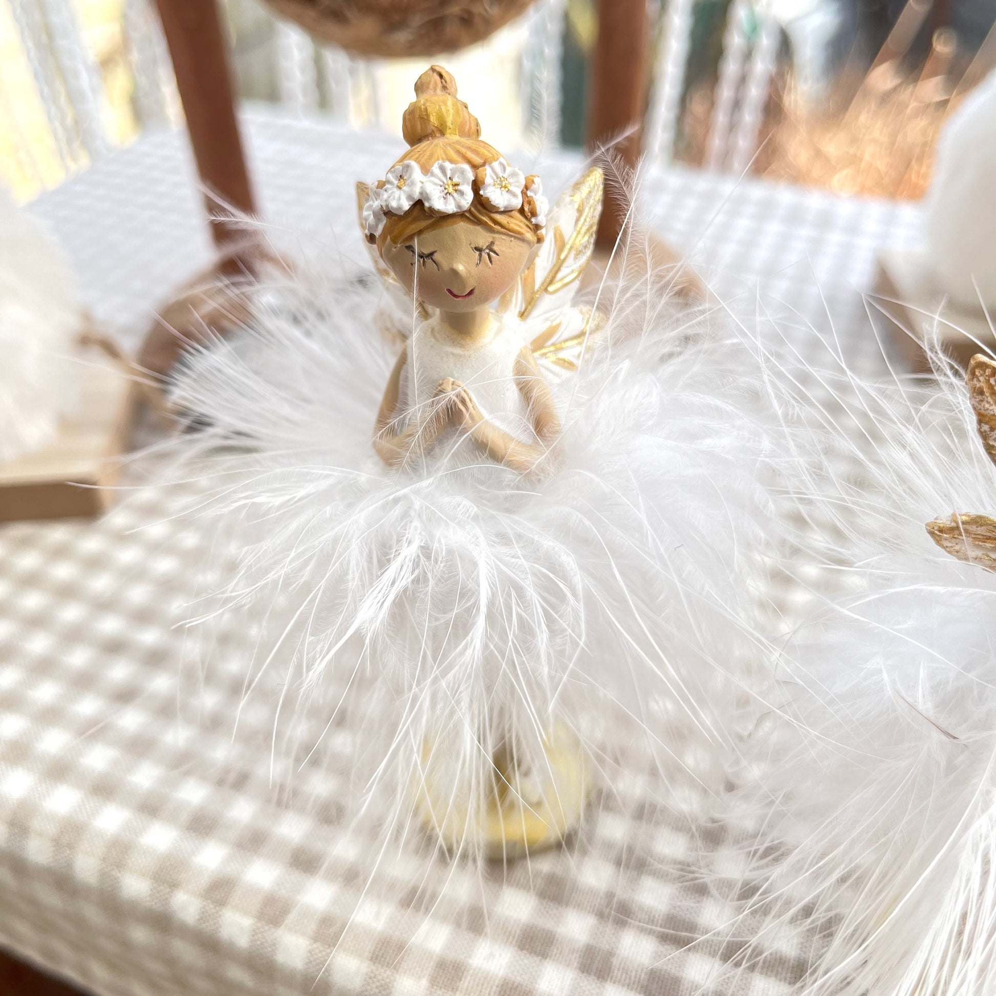 Elfe mit Federn - stehend - in weiß / gold und 2 Varianten erhältlich. Entweder mit der Hand unter dem Kinn, oder mit gefalteten Händen vor der Brust. 
Maße: Höhe ca. 12 cm 
Material: Polyresin, Federn 
Farben: rosa, apricot 
Lieferumfang: 1 Elfe in der ausgesuchten Variante