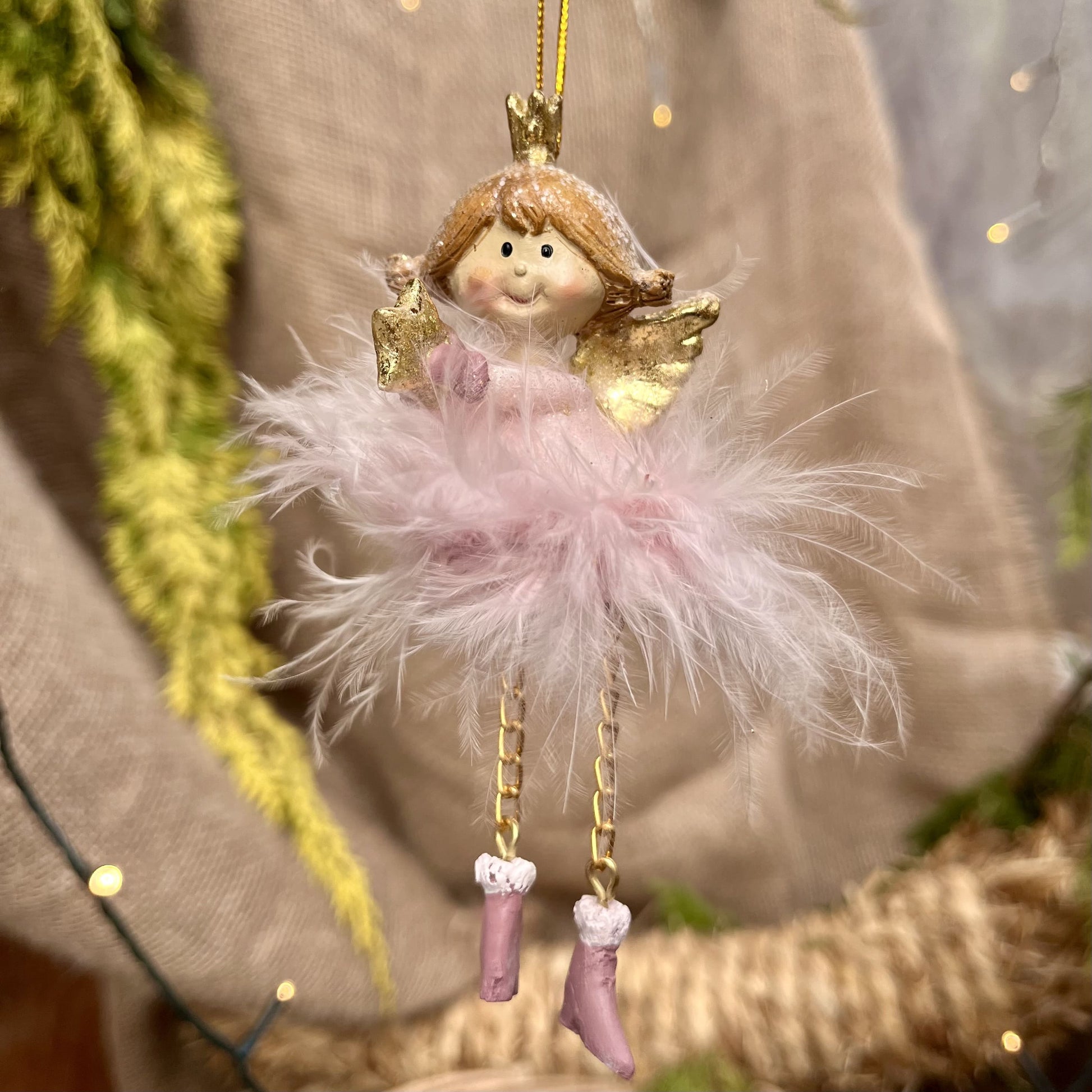 Dieser zarte Federengel mit Krönchen verleiht eurem Weihnachtsbaum eine besondere Note. Das federleichte Kleid wiegt sanft auf und ab und sorgt für eine beruhigende, festliche Atmosphäre. Mit einer Höhe von ca. 12 cm ist er in zwei eleganten rosé-Varianten erhältlich und bringt himmlischen Glanz in eure Weihnachtsdekoration.