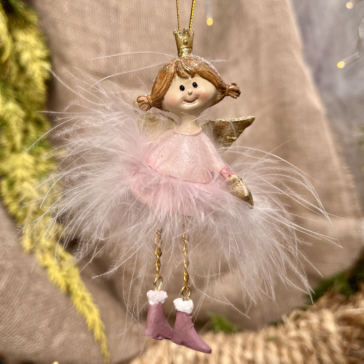 Dieser zarte Federengel mit Krönchen verleiht eurem Weihnachtsbaum eine besondere Note. Das federleichte Kleid wiegt sanft auf und ab und sorgt für eine beruhigende, festliche Atmosphäre. Mit einer Höhe von ca. 12 cm ist er in zwei eleganten rosé-Varianten erhältlich und bringt himmlischen Glanz in eure Weihnachtsdekoration.