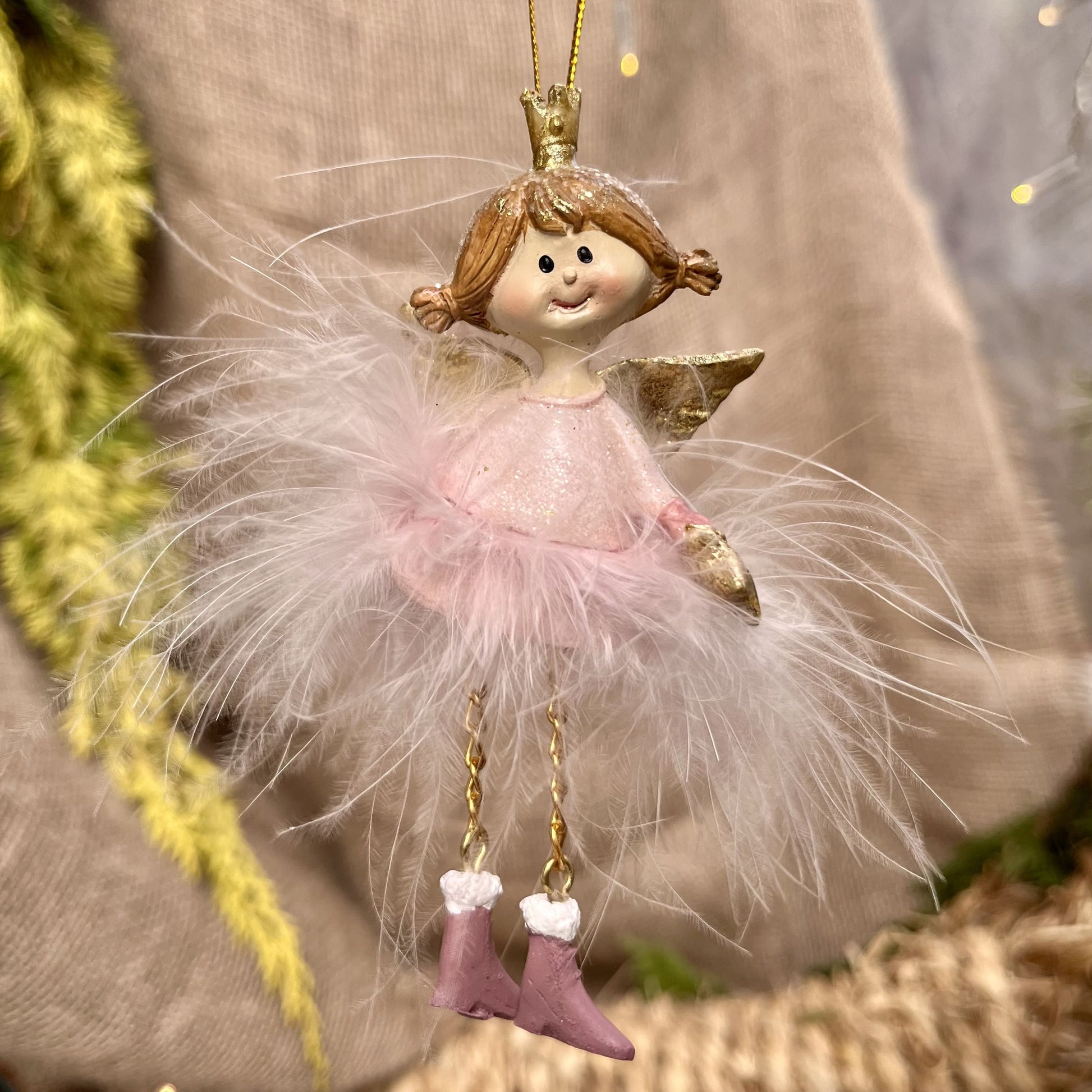 Dieser zarte Federengel mit Krönchen verleiht eurem Weihnachtsbaum eine besondere Note. Das federleichte Kleid wiegt sanft auf und ab und sorgt für eine beruhigende, festliche Atmosphäre. Mit einer Höhe von ca. 12 cm ist er in zwei eleganten rosé-Varianten erhältlich und bringt himmlischen Glanz in eure Weihnachtsdekoration.