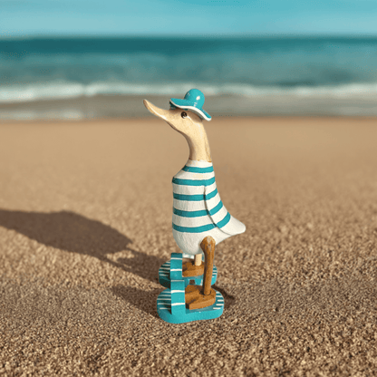 Strandente mit Sonnenhut, Flip Flops und türkis weiss gestreiftem Körper und ca. 25 cm Höhe. Wunderschöne Deko aus Bambuswurzel. Jedes Teil handgefertigt und ein Unikat aus Bali. Ein Hingucker für Drinnen und Draußen