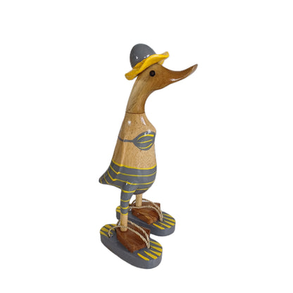 Bambusente im grauen Bikini mit gelben Streifen, Sonnenhut und Flip Flops - Höhe ca. 25 cm. Wunderschöne Deko aus Bambuswurzel. Jedes Teil handgefertigt und ein Unikat. Ein Hingucker für Drinnen und Draußen. 
Zudem stehen die Enten aus Bambus für Familie, Treue & Liebe und Holz für Wachstum. So macht es sie dadurch auch zu einem bedeutungsvollen Geschenk für einen lieben Menschen.