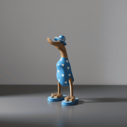 Ente aus Bambus - mit weißen Herzen, blauen Flip Flops und Sonnenhut und einer Höhe von 25 cm. Wunderschöne Deko aus Bambuswurzel. Jedes Teil handgefertigt und ein Unikat. Ein Hingucker für Drinnen und Draußen. 
Ente mit Sonnenhut und Flip Flops in blau mit weißen Herzen - Farbe: natur / blau - Material: Bambus - Maße: Höhe 25 cm