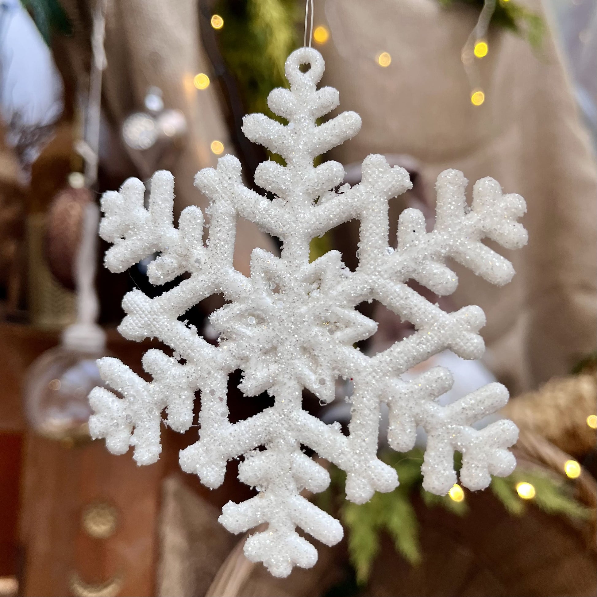 Diese zarte Schneeflocke glitzert dezent und bietet sich hervorragend für eine Dekoration auch noch nach Weihnachten an. Maße: 10 x H 10 cm + 7 cm Hänger, 
Farbe weiß,  Material Kunststoff