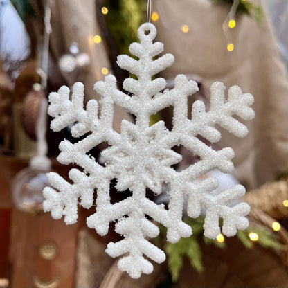 Diese zarte Schneeflocke glitzert dezent und bietet sich hervorragend für eine Dekoration auch noch nach Weihnachten an. Maße: 10 x H 10 cm + 7 cm Hänger, 
Farbe weiß,  Material Kunststoff