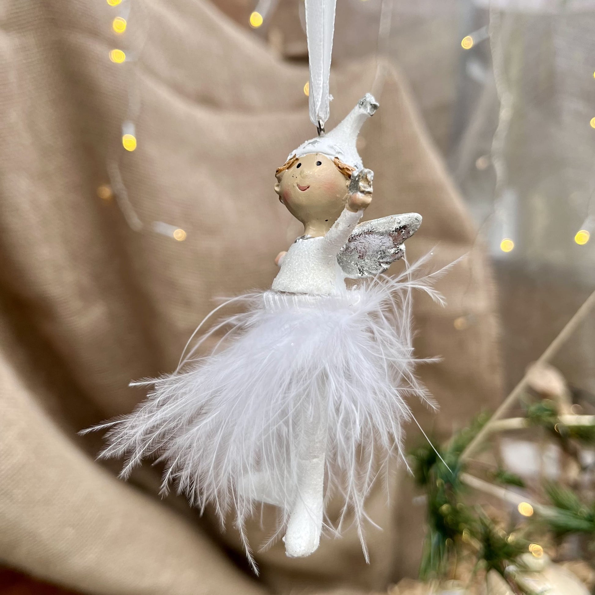 Dieser süße Engel mit Zipfelmütze bringt himmlischen Glanz in eure Weihnachtsdekoration. Sein Federrock wiegt sanft auf und ab und sorgt für eine beruhigende, festliche Atmosphäre.