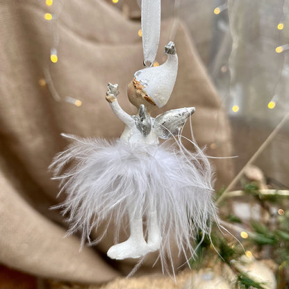 Dieser süße Engel mit Zipfelmütze bringt himmlischen Glanz in eure Weihnachtsdekoration. Sein Federrock wiegt sanft auf und ab und sorgt für eine beruhigende, festliche Atmosphäre.