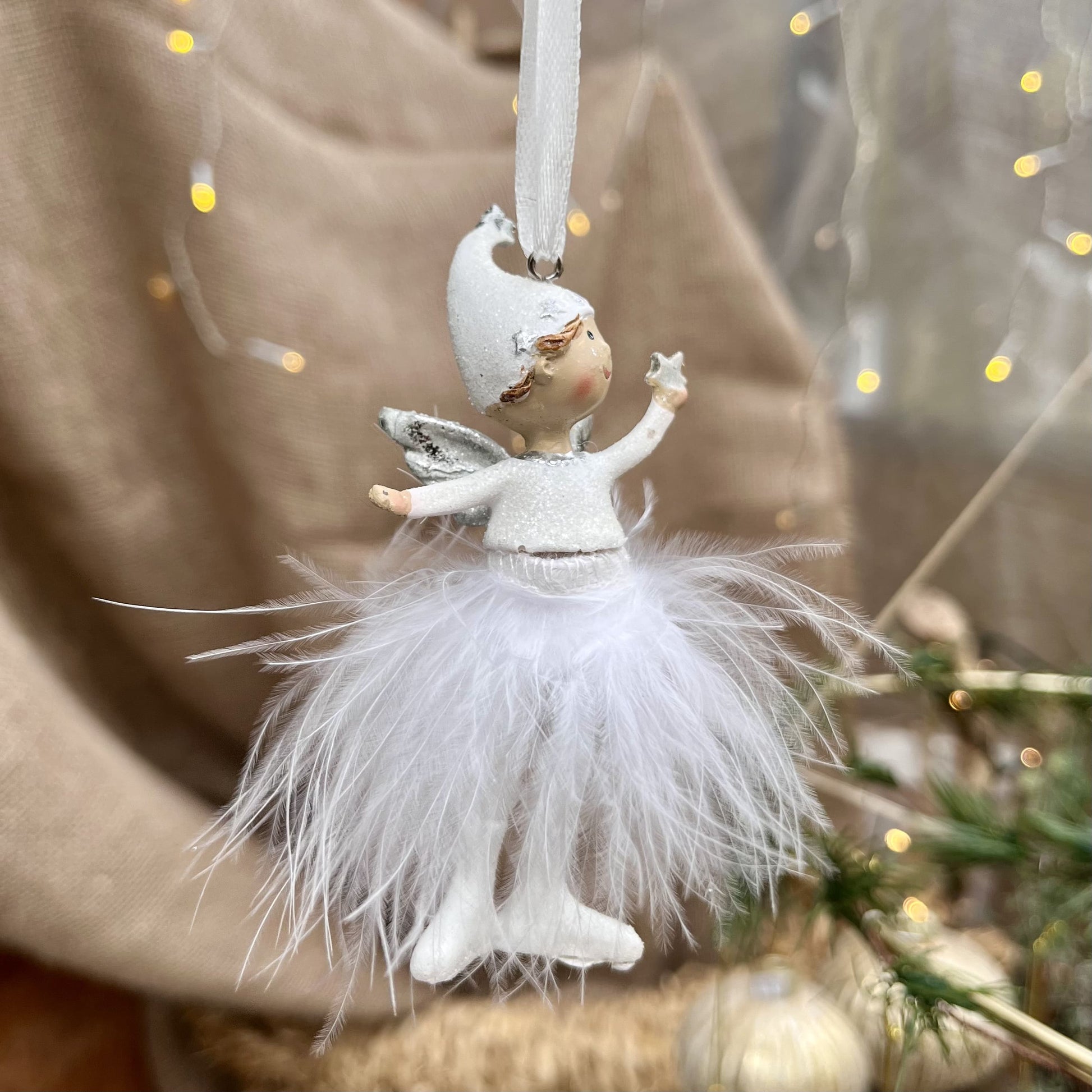 Dieser süße Engel mit Zipfelmütze bringt himmlischen Glanz in eure Weihnachtsdekoration. Sein Federrock wiegt sanft auf und ab und sorgt für eine beruhigende, festliche Atmosphäre.