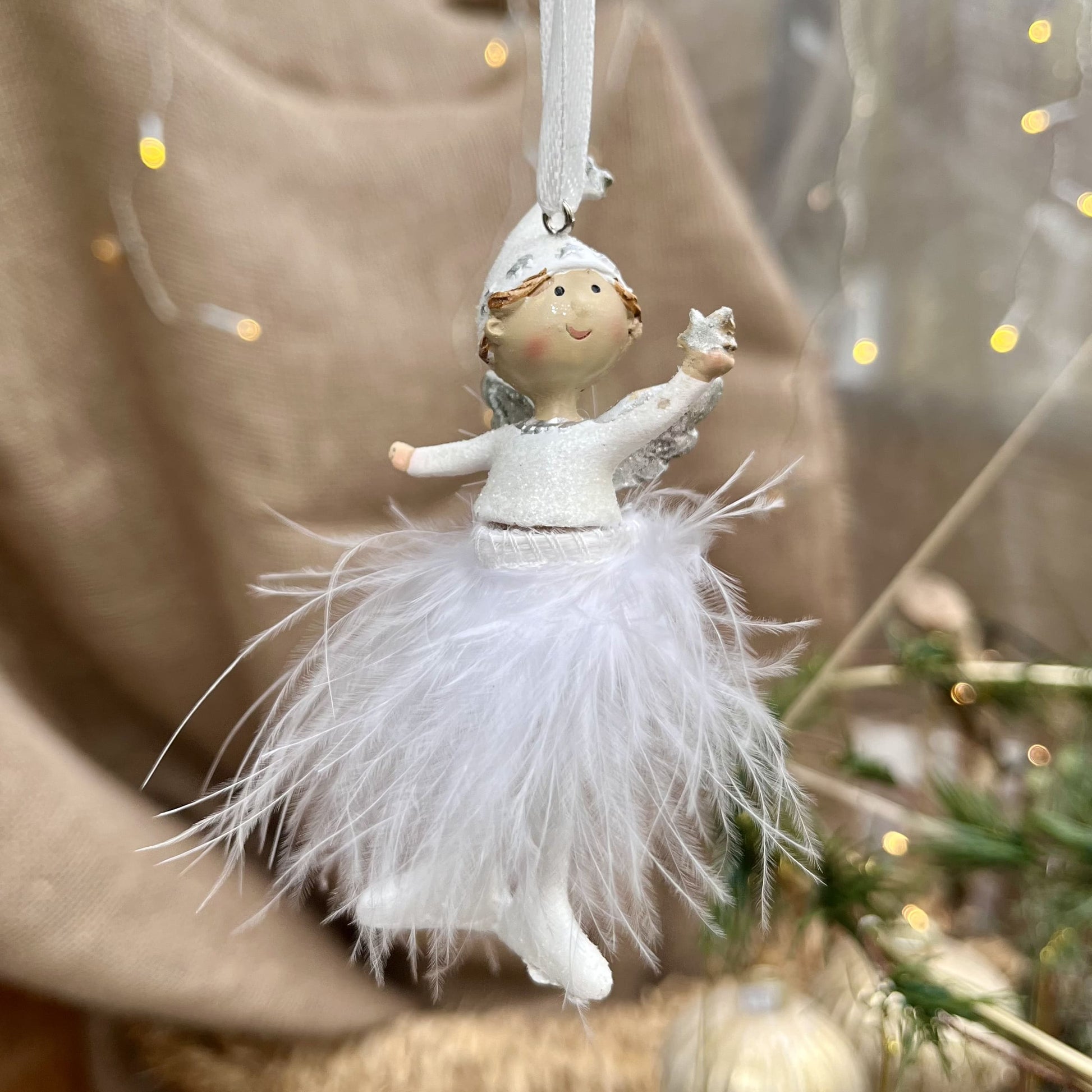 Dieser süße Engel mit Zipfelmütze bringt himmlischen Glanz in eure Weihnachtsdekoration. Sein Federrock wiegt sanft auf und ab und sorgt für eine beruhigende, festliche Atmosphäre.