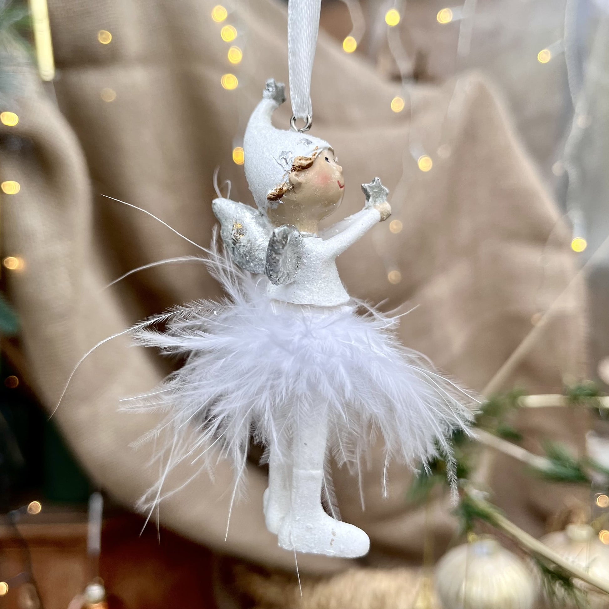 Dieser süße Engel mit Zipfelmütze bringt himmlischen Glanz in eure Weihnachtsdekoration. Sein Federrock wiegt sanft auf und ab und sorgt für eine beruhigende, festliche Atmosphäre.