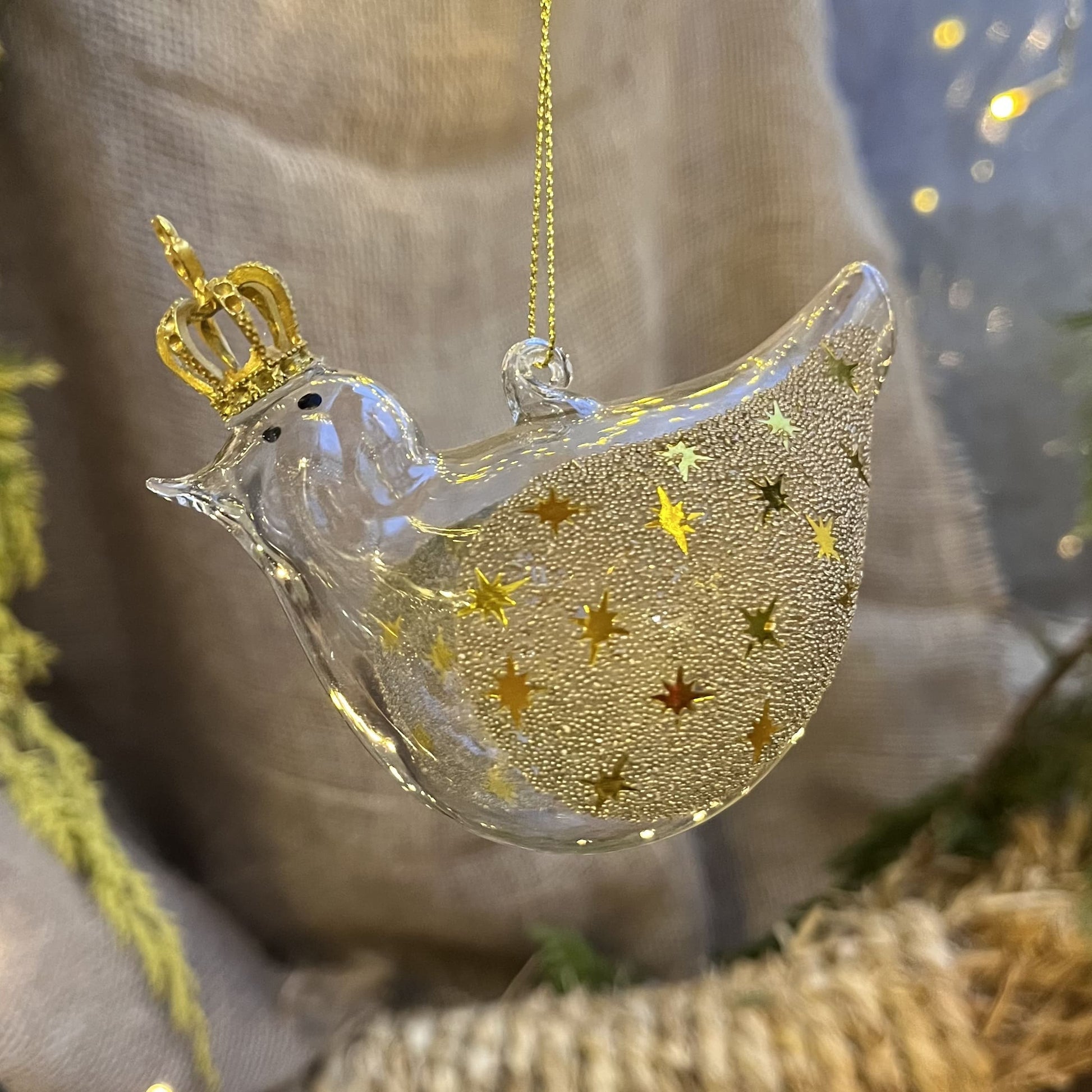 Lass dich von diesem einzigartigen und verspielten Glasvogel verzaubern! Mit seiner goldenen Krone und den mit Sternchen und Perlen besetzen Glitzerflügeln versprüht er einen ganz besonderen Charme.
Maße: ca. 10,0cm
Materialien: Glas, Perlen, Kunststoff
Farben: Gold