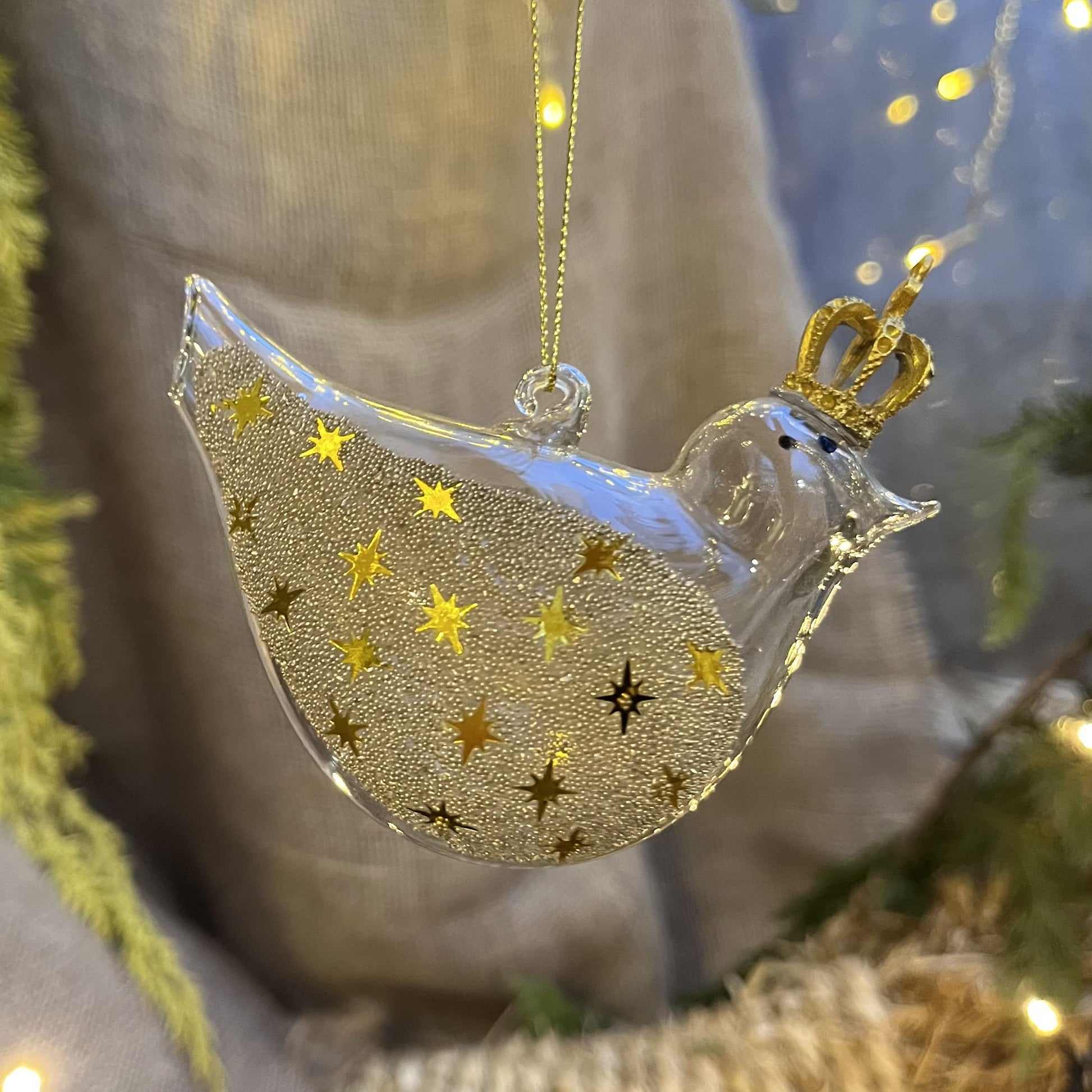 Lass dich von diesem einzigartigen und verspielten Glasvogel verzaubern! Mit seiner goldenen Krone und den mit Sternchen und Perlen besetzen Glitzerflügeln versprüht er einen ganz besonderen Charme.
Maße: ca. 10,0cm
Materialien: Glas, Perlen, Kunststoff
Farben: Gold