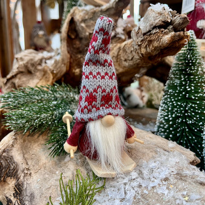 Wichtel auf Ski mit Strickmütze in roter oder grauer Mütze