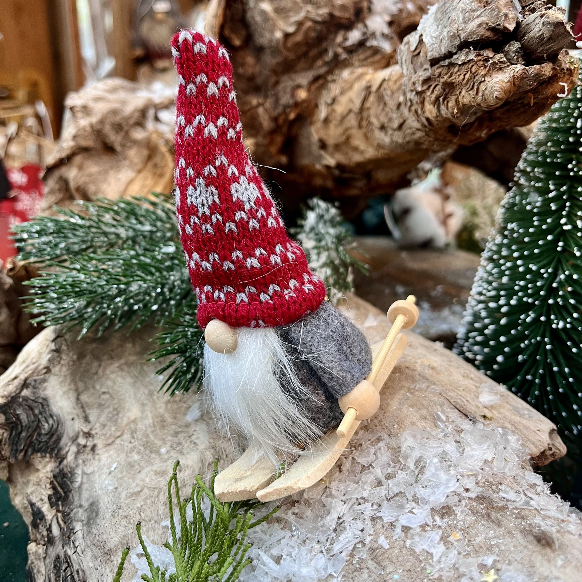 Wichtel auf Ski mit Strickmütze in roter oder grauer Mütze